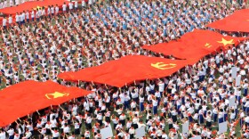 Thousands of Chinese students holding Communist flags gather to mark the 90th anniversary of the founding of China's Communist Party at a school in Taiyuan, north China's Shanxi province on May 30, 2011.