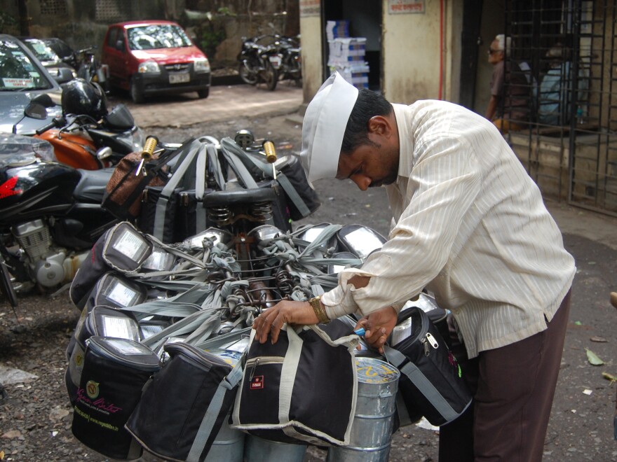A <em>dabba wallah</em> checks his packages before delivering hot meals to office workers in Mumbai.