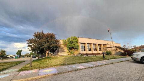 A rainbow rises over the Evansville Municipal Building June 10, the day residents covered the sidewalk with bright chalk messages and symbols.