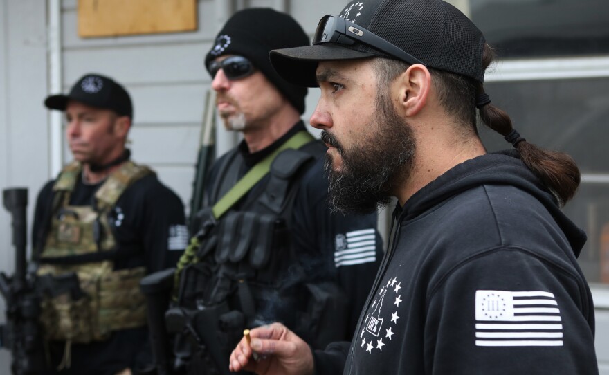Parker listens with other members after a convoy protection training exercise in January. Even if Parker is a long-shot candidate against a popular, five-term incumbent, the experience gives his ideology a bigger platform, potentially drawing recruits through his boots-to-suits transformation.