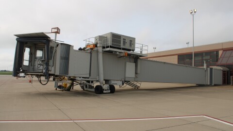A picture of an airport boarding gate, not attached to a plane and not in operation.