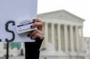 An abortion-rights activist holds a box of mifepristone pills as demonstrators from both anti-abortion and abortion-rights groups rally outside the Supreme Court in Washington, March 26, 2024. (Amanda Andrade-Rhoades/AP)