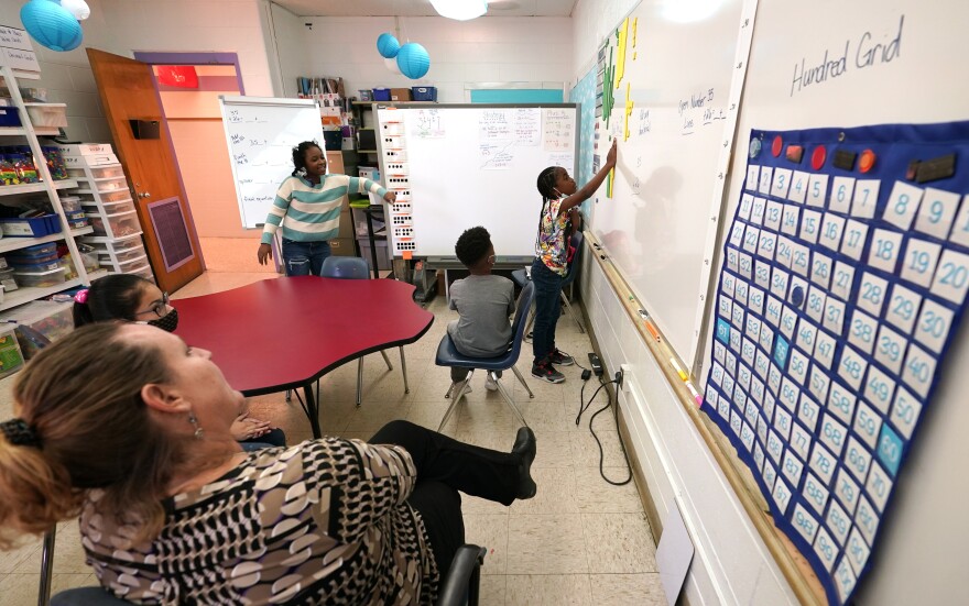 Fourth grade math teacher Martha Commander, left, instructs her class during classes at Chimborazo Elementary School Thursday, Nov. 17, 2022, in Richmond, Va.