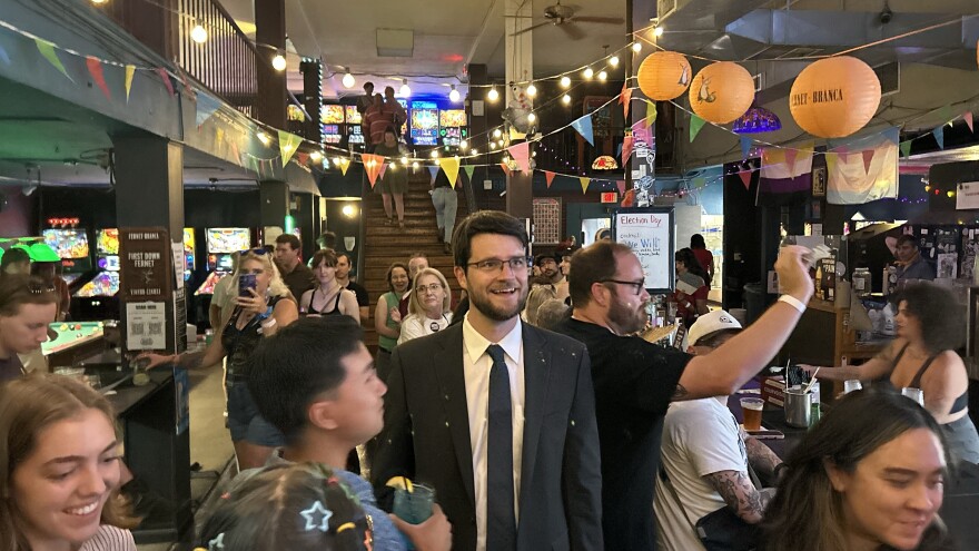 William Lawrence looking up ahead in a crowded bar