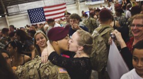 a couple kisses after being reunited after a deployment