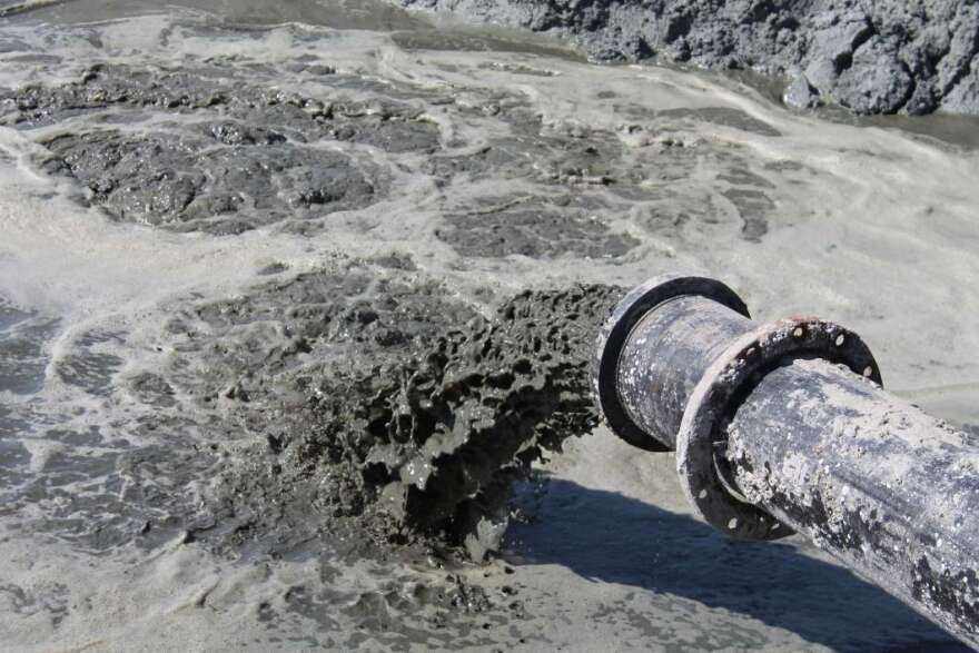 Muck pours from a pipe into a seven-acre island retention site in the Indian River Lagoon. Photo by Amy Green