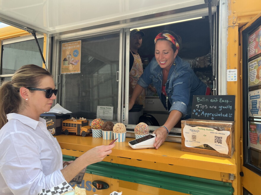 Emily Grace, co-owner of the food truck, serves a customer some of Goodness Gracious' handcrafted ice-cream balls, made in marshmallows and a cruchy cereal shell.