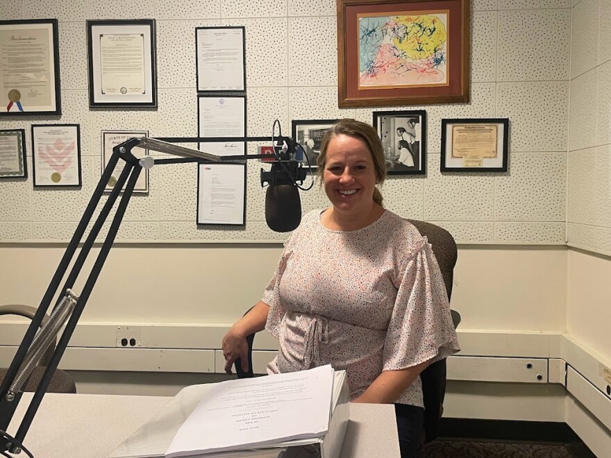 McLean County State's Attorney Erika Reynolds smiles in a WGLT studio while sitting behind a microphone.