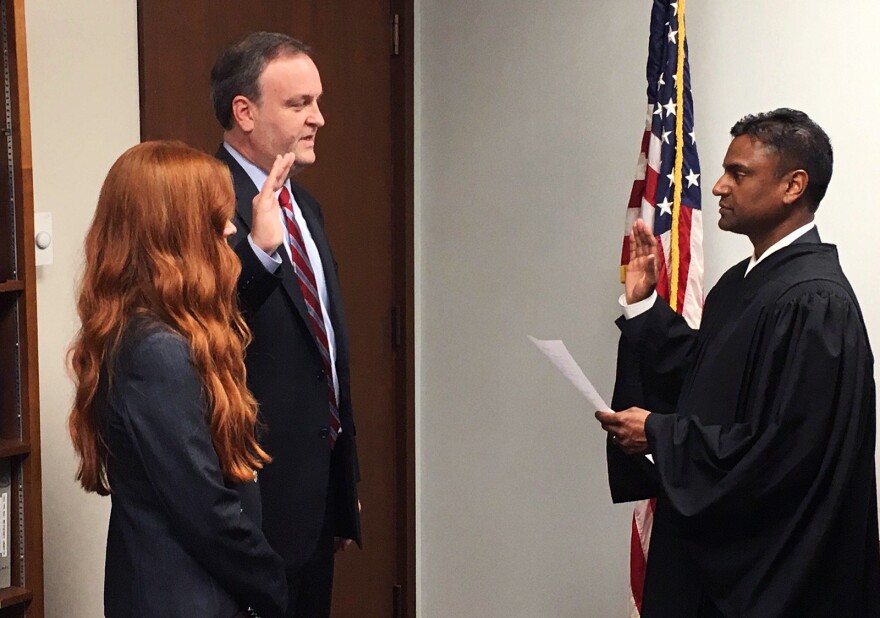 St. Louis County Councilman Sam Page (left), joined by his wife, Dr. Jennifer Page, is sworn in by Administrative Hearing Commissioner Sreenivasa Rao Dandamudi Monday to take over as county executive following Steve Stenger's resignation from the office.