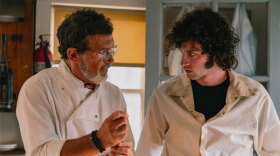 Antonio Banderas as Chef, and Dominic Sessa as a young Anthony Bourdain. Both are wearing white chef smocks