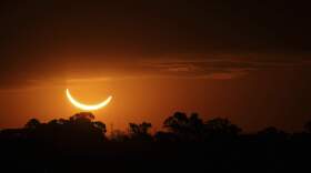 The moon passes in front of the setting sun during a total solar eclipse. (Marcos Brindicci/AP)