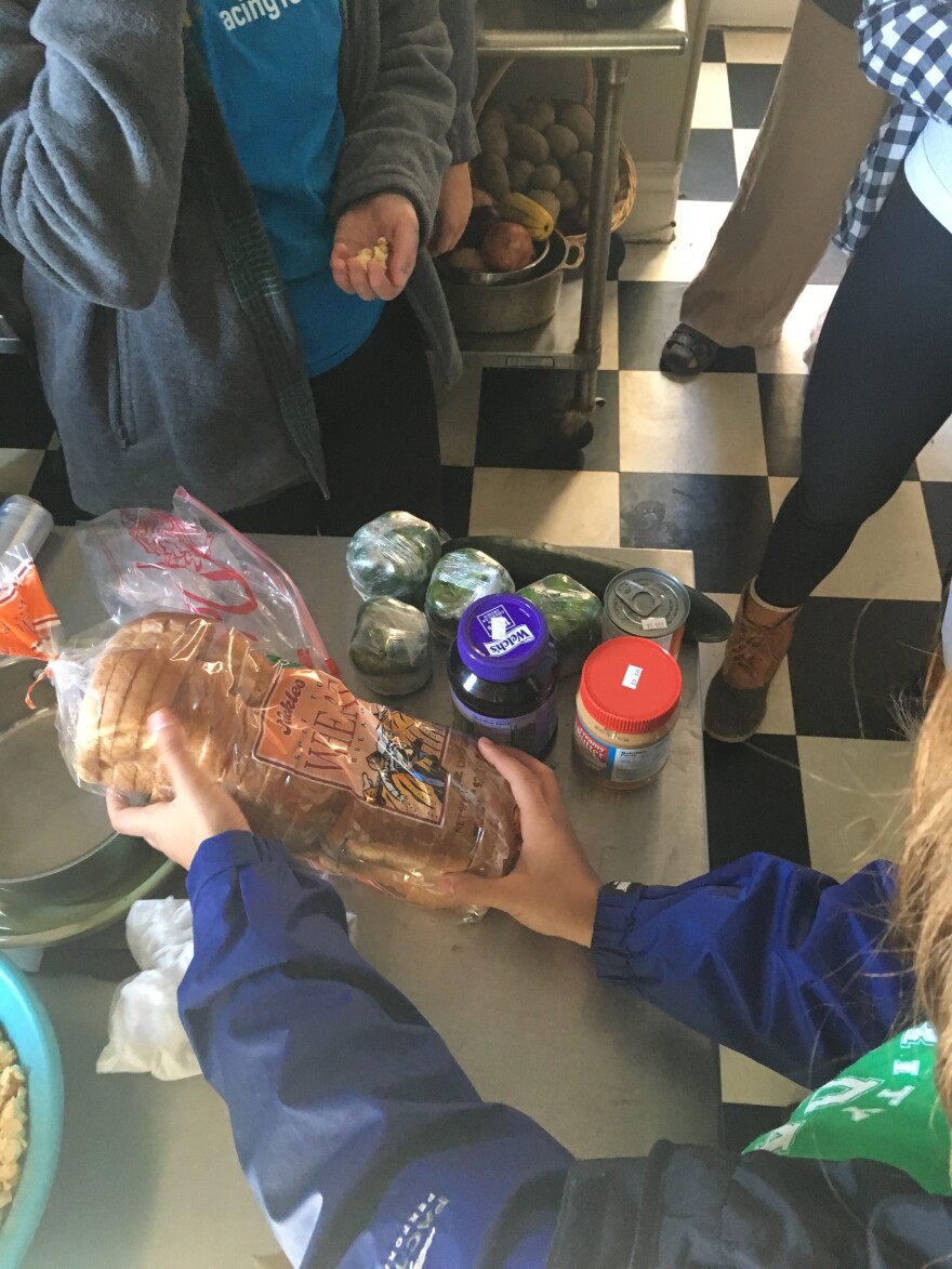 Students quickly decided to pool their money. They bought a loaf of wheat bread, an off-brand jar of peanut butter, jelly, and with the remaining coins, they bought several green bell peppers and a cucumber. No one bought anything to drink.