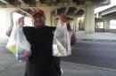 Mission outreach coordinator Daniel Watts hands out snacks for homeless still living under the Pontchartrain Expressway recently cleared to make way for more downtown parking.
