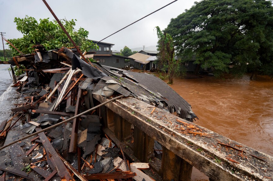 Debris from a storm-damaged house sits against a bridge along Kaukonahua Stream, caused by flooding from severe rains in Waialua, Hawaiʻi, Friday, March 20, 2026.