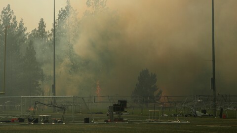 Old Trails Fire burns near Dwight Merkel Sports Complex, Saturday, Aug. 1, 2026, in Spokane, Wash. (AP Photo/Young Kwak)