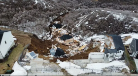 An aerial shot of where the two homes collapsed and slid down the canyon. There is still a lot of large debris where the ground has given way and slid down.