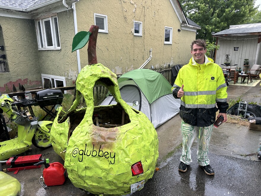24-year-old sculpture artist Andrew Glubbey smiles next to his magnum opus, "Pear Car." He stopped in Missoula for a week in late June to swap the broken scooter beneath the pear for a more powerful touring motorcycle.