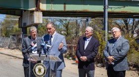 Robert Rocchio, acting director of the Rhode Island Department of Transportation, speaks near the scene of a partial bridge collapse in Cranston, as Gov. Dan McKee, Cranston Mayor Ken Hopkins and RIDOT engineer John Preiss look on.
