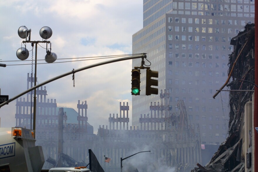 "New York City, USA - September 29, 2001: The World Trade Center site at Ground Zero, debris and vehicles seen spread around the area already 2 weeks after the September 11, 2001 disaster. Fires are still burning underground and smoke and haze fills the sky."