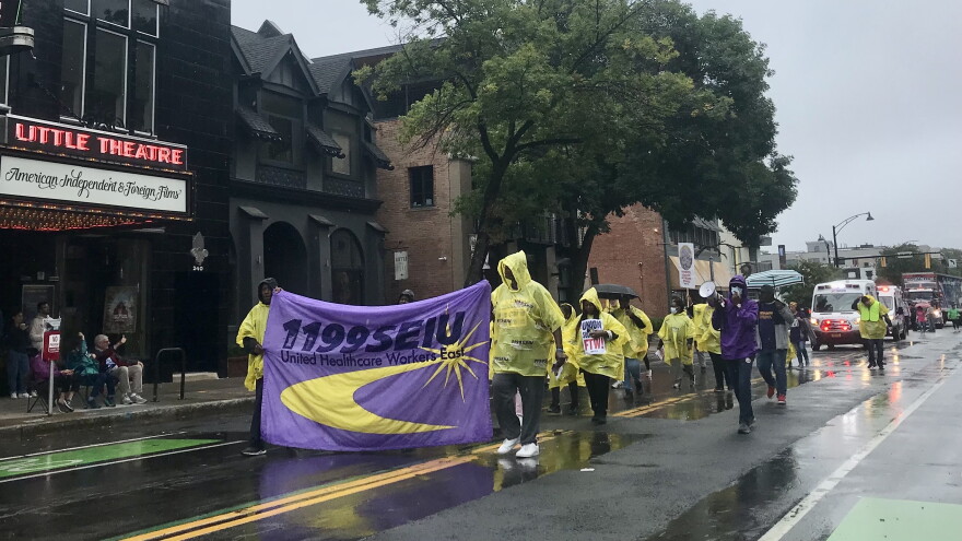 Union workers with the 1199 United Healthcare Workers East marched down East Avenue on Labor Day, Monday, in the rain as spectators clapped and cheered from underneath the Little Theatre marquee.