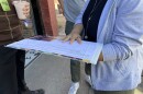 Chimene Schwach holds a clipboard with signature sheets for the abortion initiative petition.