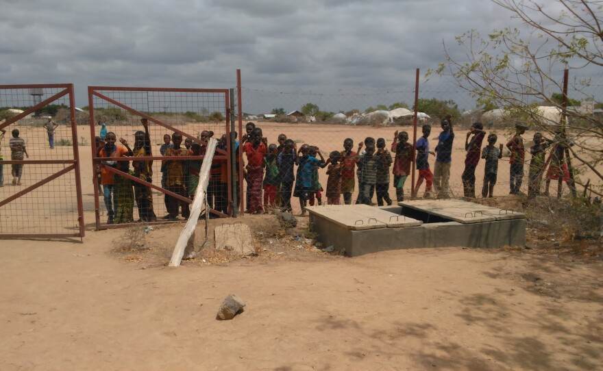 Residents of the Dadaab refugee camp gather around to watch the 'Mzungu' - white girl - climb the water tower for a bird's eye view 