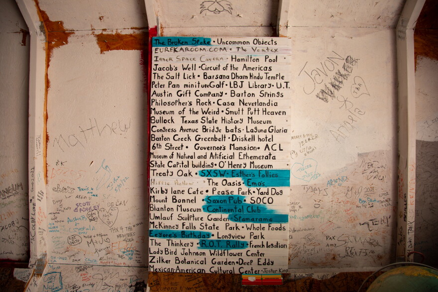 A list of notable Austin locations are written on a wall with some names highlighted in blue.