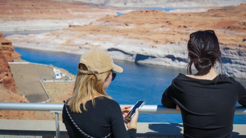 Visitors look over Lake Powell from a viewpoint at the Glen Canyon Dam, Oct. 5, 2025. Years of drought and overuse across the Colorado River Basin have shrunk water levels at Lake Powell, the nation's second-largest reservoir.