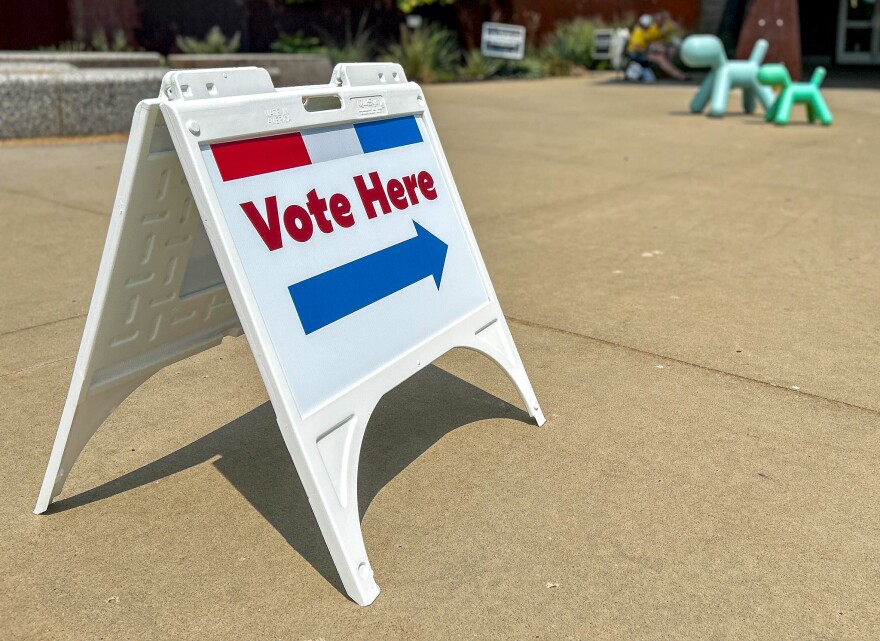 A "Vote Here" sign directs voters inside the Johnson County Art & Heritage Center on August 4, 2026.