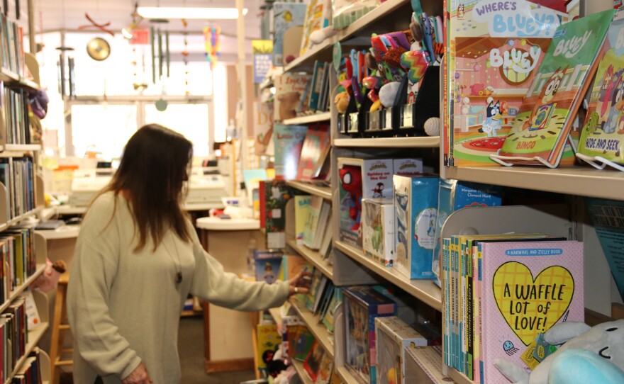 Staff member Connie Kinsey organizes books on a shelf at Book Gallery West. The store is located at 4121 NW 16th Blvd. (Kevin Perez/WUFT News)