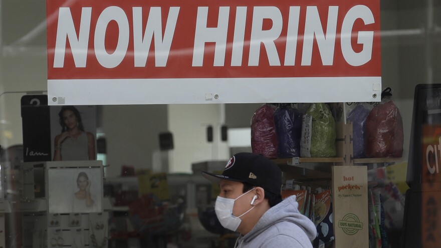 A man walks by a CVS Pharmacy in San Francisco on May 7. U.S. employers unexpectedly added jobs last month as the unemployment rate fell.