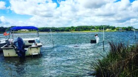 Captain Chris Ludford checking oyster cages. Photo Credit: Amber McCluney