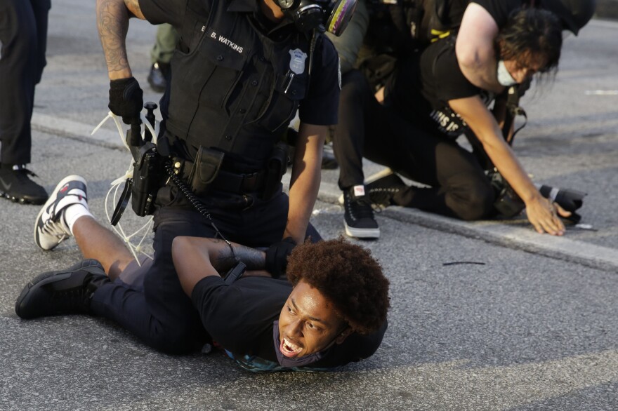 Demonstrators are detained by police during a protest in Atlanta. The protest started peacefully earlier in the day before demonstrators and police clashed.