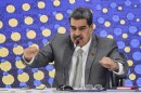 Nicolas Maduro gestures as he talks at a table.
