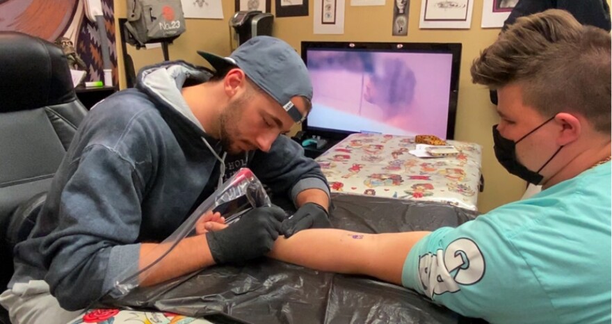 Matt Spyrou tattoos multiple clients during a flash tattoo sale.