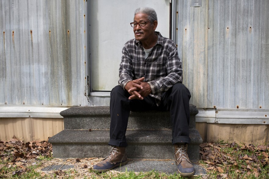 Levi Grissett sits on the steps of a trailer that he and his wife shared on his family's land in Supply, N.C.