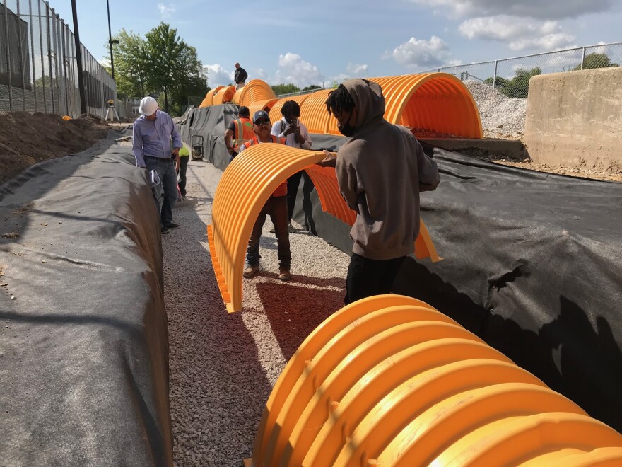 Dontae Luttrell helping team install underground cistern next to North Division's tennis courts.