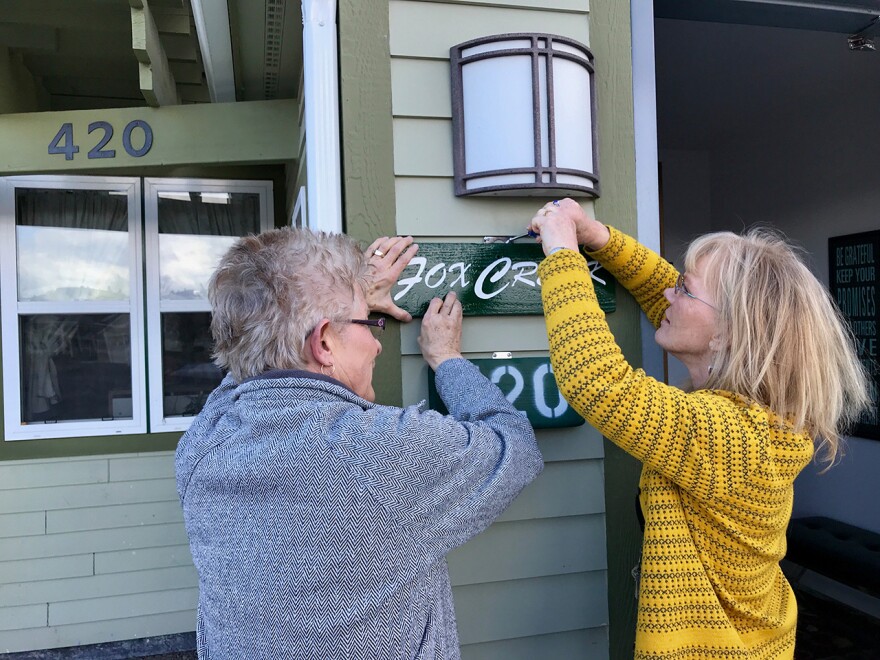 Sheila Smith and Paula Buckley affix a new sign to the former Sinopah House, March 30, 2018 in Kalispell.