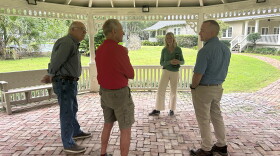 Barbara Hooper, who helped organize the festival, discusses Saturday's logistics with three members of Pasture Prime Bluegrass: Mike Matz (left), Will Harding (middle) and Brian Young (right).
