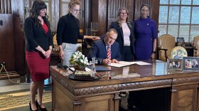 Gov. Mike Kehoe signs into law Tuesday legislation that removes legal barriers for pregnant women seeking divorce, while, from left, Rep. Ashley Aune, Sen. Jill Carter, Rep. Cecelie Williams and Rep. Raychel Proudie watch.