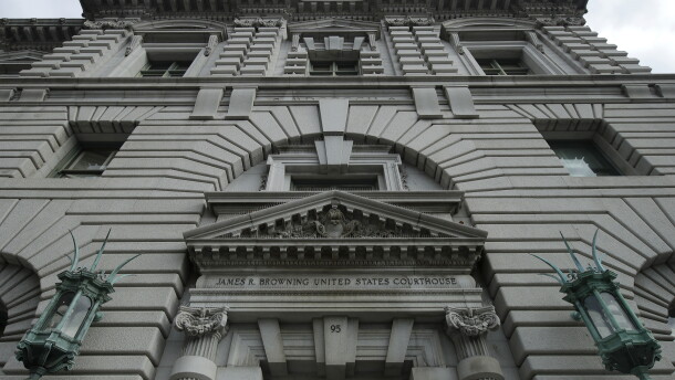 A gray building with bronze light posts flanking either side of the entrance.