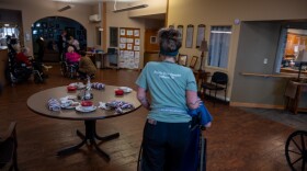 A worker at the Prairie View Nursing Home in Sanborn, Iowa, wheels a resident after lunch. The nursing home has faced chronic staffing shortages that were made worse by the COVID-19 pandemic.