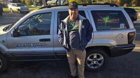 Benjamin Strongwolf posing in front of his car, with logos for Ghost Contact Paranormal and Paranormal Investigation Unit