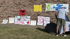 Protestors lined their signs up outside of the Talihina Junior High School auditorium before they headed in for a meeting with federal regulators.