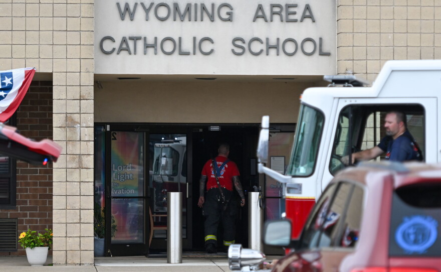 A firefighter enters the Wyoming Area Catholic school after a fire was extinguished on Tuesday, Sept. 1, 2026.