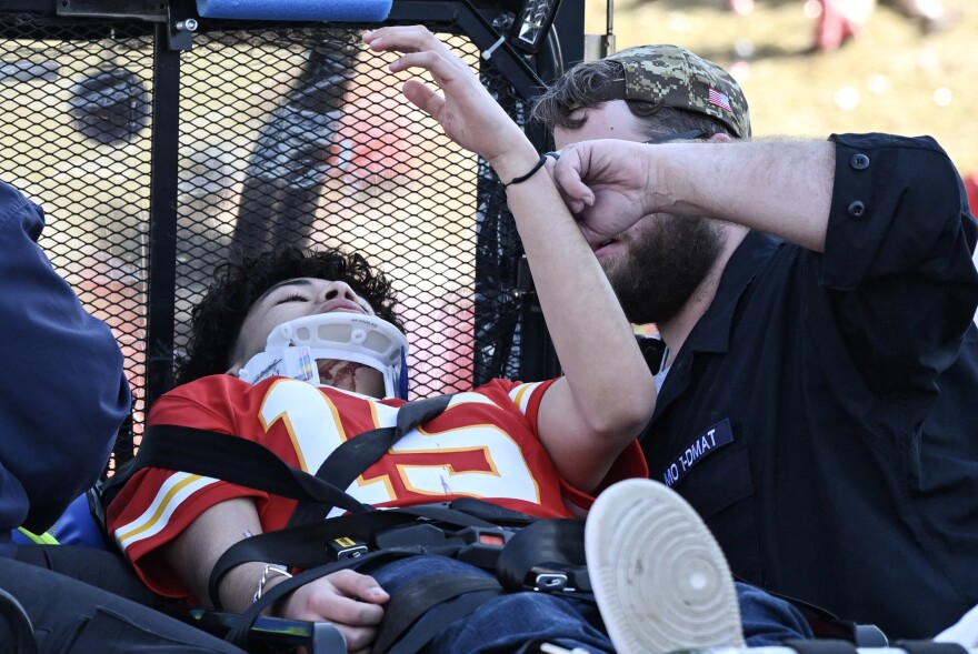 An injured person is aided near the Kansas City Chiefs' Super Bowl LVIII victory parade.