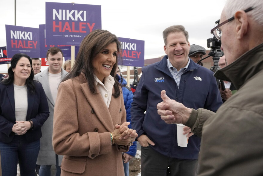 Haley, center left, and N.H. Gov. Chris Sununu, center right, greet people near a polling site at Winnacunnet High School in Hampton.