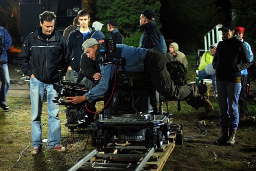 Set photo of a camera man adjusting equipment at night