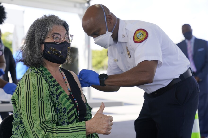 Miami-Dade County Mayor Daniella Levine Cava gives a thumbs up after getting her first dose of Pfizer's COVID-19 vaccine from Capt. Will Hall, COVID-19 Vaccine Branch Director for the county, Wednesday, March 17, 2021, at the Miami-Dade County Tropical Park COVID-19 vaccination site in Miami.