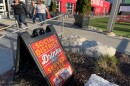 A sign outside the Lansing Brewing Company in Lansing, Michigan advertises a social district where people can buy alcohol-to-go and drink it within the boundaries of an outdoor downtown zone.